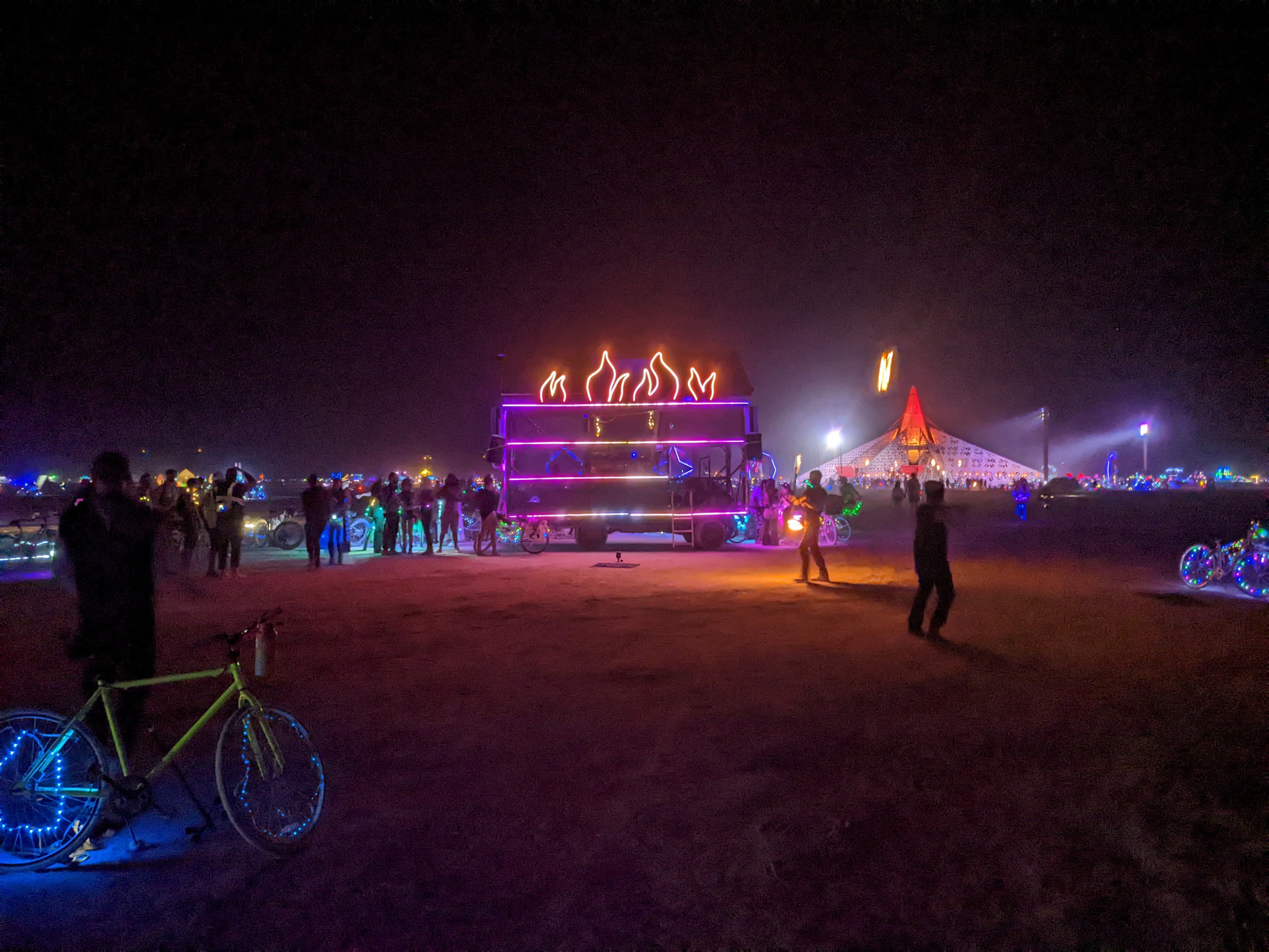 Dumpy Fuego hosting a fire circle in front of the temple at Burning Man 2022